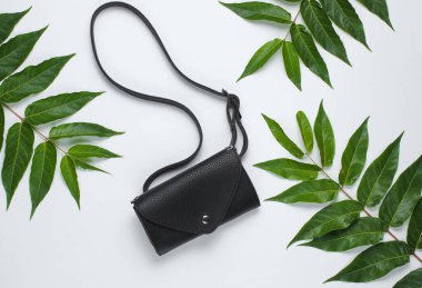 Beyaz arka planda yeşil tropikal yapraklı deri bel çantası. Üst görünüm