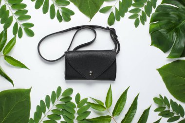 Beyaz arka planda yeşil tropikal yapraklı deri bel çantası. Üst görünüm