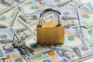 Dolar banknotlarının arka planında anahtarı olan altın kilit
