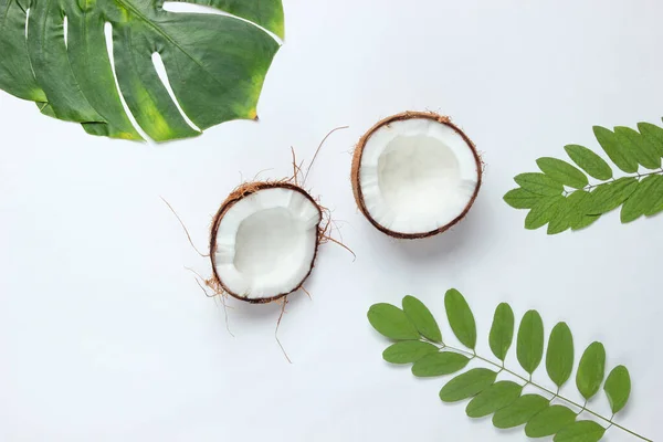 Twee Helften Gehakte Kokosnoot Witte Achtergrond Met Groene Bladeren — Stockfoto