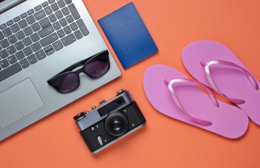 Yaz tatili. Yaz tatili istirahatı. Laptop ve mercan zemininde plaj aksesuarları. Stüdyo kısa. Plaj objesi. Üst Manzara. Düz yatıyordu