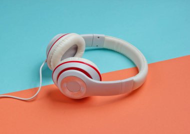 Renkli kağıt arka planda klasik beyaz kulaklıklar. Retro tarzı. 80 'ler. Popüler kültür. Asgari Müzik Konsepti