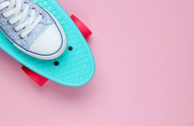 Pembe arka planda kaykaylı spor ayakkabılar. Minimalizm moda kavramı