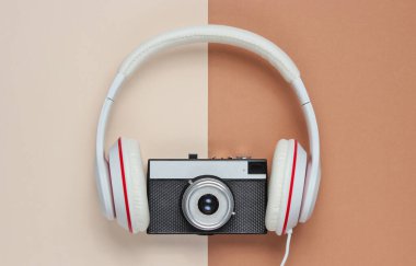 Kahverengi-bej arka planda retro kameralı kulaklıklar. Üst görünüm, minimalizm