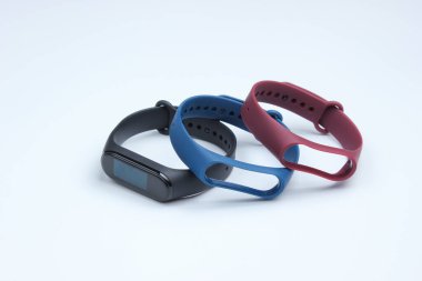 Beyaz arka planda değiştirilebilir bilezikleri olan akıllı bir saat. Fitness takip cihazı. Modern aygıtlar