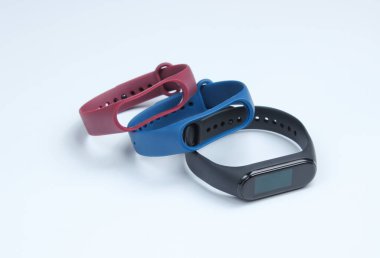 Beyaz arka planda değiştirilebilir bilezikleri olan akıllı bir saat. Fitness takip cihazı. Modern aygıtlar