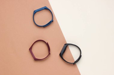 Renkli arka planda değiştirilebilir bilezikleri olan akıllı saat. Fitness takip cihazı. Modern aygıtlar