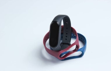 Beyaz arka planda değiştirilebilir bilezikleri olan akıllı bir saat. Fitness takip cihazı. Modern aygıtlar