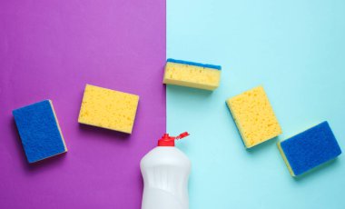 Bulaşık yıkamak için ev hanımları. Bulaşıkçı. Bir şişe kap kacak, mavi mor arka planda süngerler. Üst görünüm.