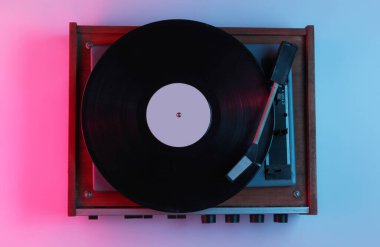Retro tarzı müzik konsepti. Gradyan pembe neon ışıklı vinil plak çalar. Popüler kültür. 80 'ler.