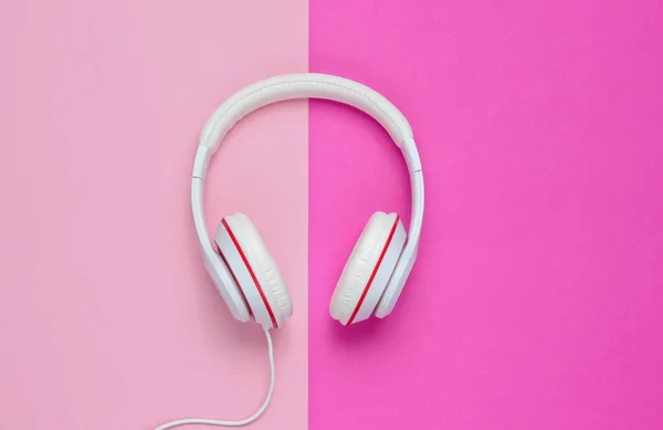 Classic white wired headphones on colored paper background. Retro style. 80s. Pop culture. Top view. Minimal Music Concept