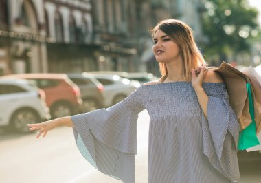 Genç ve çekici bir kadın şehirde bir arabaya biniyor.