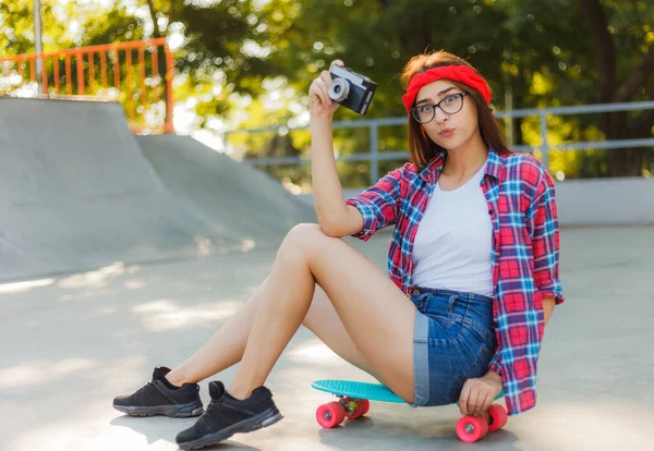 Funny Young Woman Stylish Clothes Sits Skateboard Uses Retro Camera — Stock Photo, Image