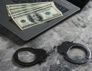 Siber suçlar, online dijital hırsızlıklar. Bir dolar banknotlu dizüstü bilgisayar.