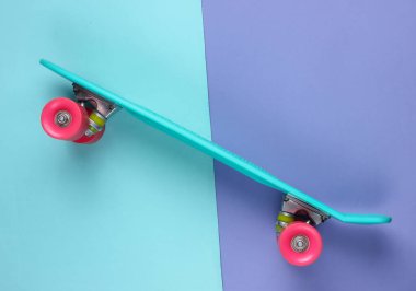 Renkli arka planda plastik mini kruvazör tahtası. Pastel renk eğilimi. Yaz eğlencesi. Gençlik minimalist konsepti. Üst görünüm