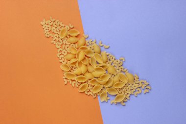 Kahverengi arka planda farklı çiğ İtalyan makarnası çeşitleri. Üst görünüm.
