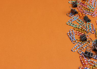 Kahverengi arka planda bir sürü renkli ataç var. Minimalist ofis kavramı. Boşluğu kopyala