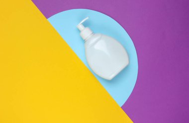 Renkli kağıt arka planda şampuan şişesi. Üst Manzara. Asgari güzellik konsepti.