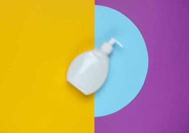 Renkli kağıt arka planda şampuan şişesi. Üst Manzara. Asgari güzellik konsepti.