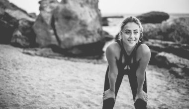 Vahşi bir sahilde spor giyimli, çekici bir kadın..