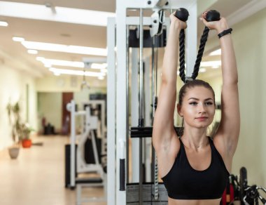 Çekici, formda bir kadın spor salonunda trisepsleri çalıştırıyor..