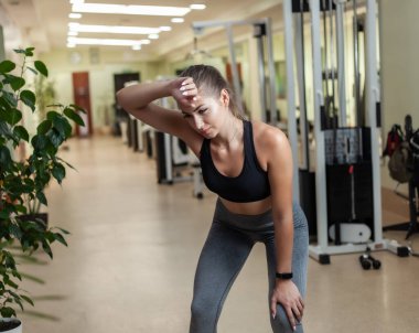 Spor salonunda spor giyim bölümünde yorgun ve zayıf bir kadının portresi. Yoğun Egzersiz Konsepti