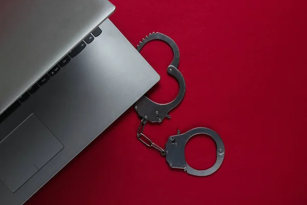 Cyberprzestępczość Cyfrowa Kradzież Online Laptop Stalowymi Kajdankami Czerwonym Tle Widok — Zdjęcie stockowe