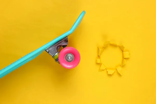 破れた穴を持つ黄色の背景にプラスチックミニクルーザーボード パステルカラーのトレンド 夏の楽しみ 若者のミニマリズムの概念 トップ表示 — ストック写真