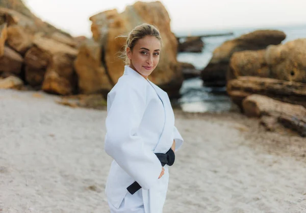 若い魅力的な武道の肖像画野生のビーチで黒いベルトと白い着物のマスター女性 — ストック写真