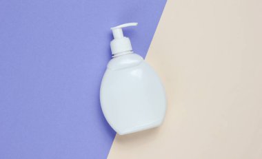 İki tonluk bir arka planda bir şişe sıvı sabun. Duş jeli, şampuan. Üst görünüm