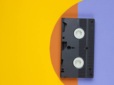 Renkli kağıt arka planda video kaset. Stüdyo moda çekimi. 80 'ler, popüler kültür. Üst görünüm.