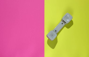 Neon renkli arka planda üç Retro telefon ahizesi. Popüler kültür. 80 'ler. Minimalist moda çekimi. Üst görünüm