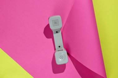 Üç Retro telefon ahizesi neon renkli kağıt arka planda. Popüler kültür. 80 'ler. Minimalist moda çekimi. Üst görünüm