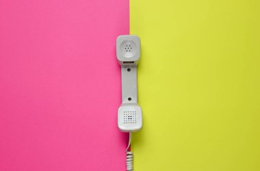 Neon renkli arka planda üç Retro telefon ahizesi. Popüler kültür. 80 'ler. Minimalist moda çekimi. Üst görünüm