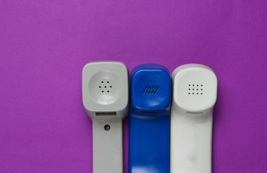 Mor arka planda üç eski telefon ahizesi. Üst Manzara. Merkezi ara. Yardım hattı.