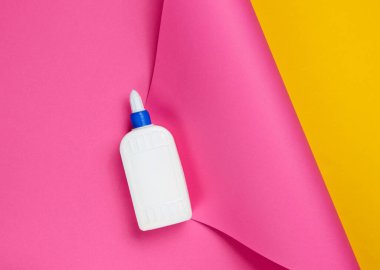 Stüdyo kağıdının arka planında bir şişe tutkal. Üst görünüm