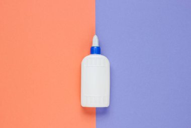 Stüdyo kağıdının arka planında bir şişe tutkal. Üst görünüm