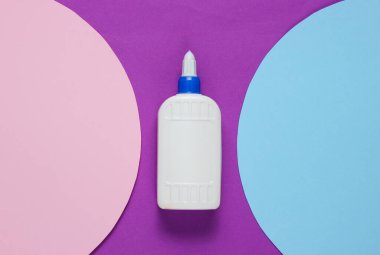 Bir şişe yapıştırıcı ve mor bir arka planda daireler. Üst görünüm