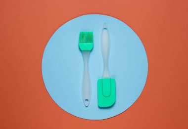 Kahverengi arka planda mutfak aletleri ve ortasında mavi daire. Minimalist mutfak hala hayat dolu. Üst görünüm