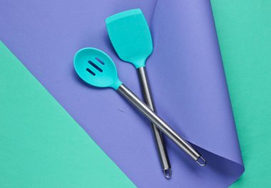 Kağıt kaplama arka planda mutfak aletleri. Minimalist yemek pişirme, hayat devam ediyor. Pastel renk eğilimi