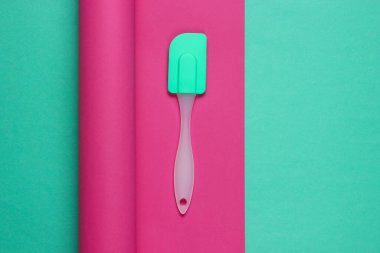 Kağıt kaplama arka planda mutfak shpatula 'sı. Minimalist yemek pişirme, hayat devam ediyor. Pastel renk eğilimi