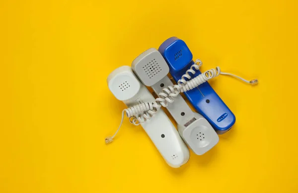 Drie Telefoonbuizen Gewikkeld Kabel Een Gele Studio Achtergrond Call Center — Stockfoto