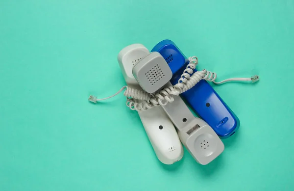 Drie Telefoonbuizen Gewikkeld Kabel Een Blauwe Studio Achtergrond Call Center — Stockfoto