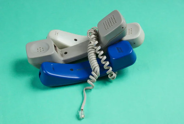 Drie Telefoonbuizen Gewikkeld Kabel Een Blauwe Studio Achtergrond Call Center — Stockfoto