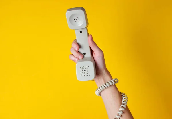 Vrouwelijke Hand Verpakt Kabel Houdt Telefoonbuis Tegen Gele Achtergrond Havenkunst — Stockfoto