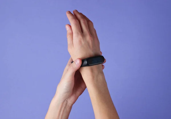 Female Hand Takes Smart Bracelet Purple Background Top View — Stock Photo, Image