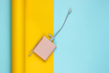 Kağıt kaplama arka planda güç bankası. Pastel renk eğilimi, minimalist durgun yaşam. Modern aletler. Üst görünüm