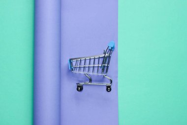 Ambalaj kağıdında alışveriş arabası. Renkli trend, minimalist güzellik ve moda natürmort. Üst görünüm