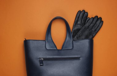Kahverengi kağıtta deri çanta ve eldivenler. Minimalist moda hala hayattadır. Düz yatıyordu. Üst görünüm