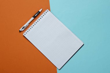 Renkli kâğıt arkaplanlı kalemli defter. Üst görünüm